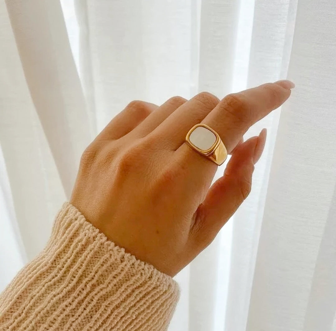 Gold plated white shellfish ring on a hand