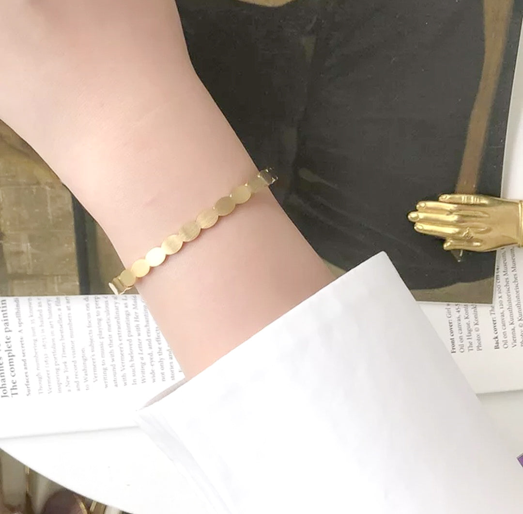 Wavy shape gold plated bracelet on hand