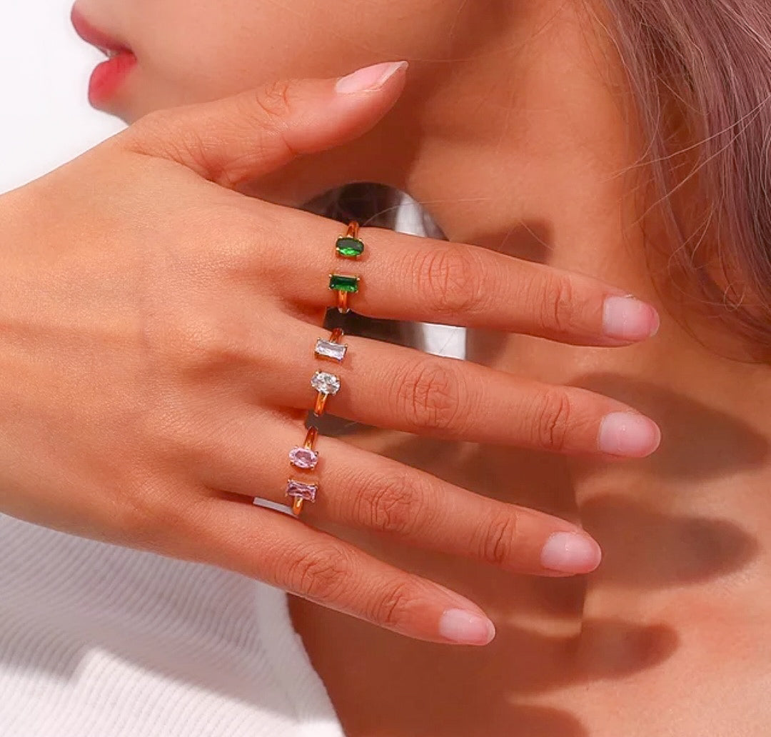 Gold plated small zircon rings on a hand in color green, white and pink