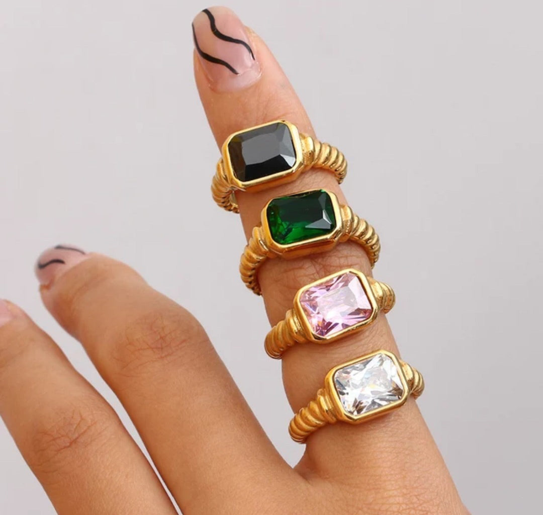 Gold plated chunky gemstone rings in color green, pink and white on a hand